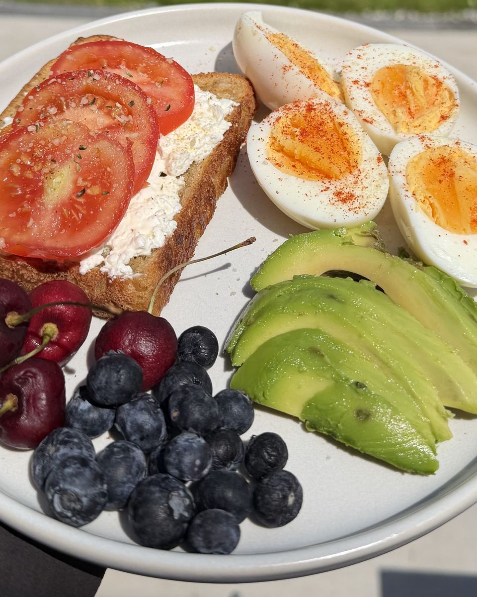 Toast with cottage cheese and tomato, boiled eggs, avocado and berries
